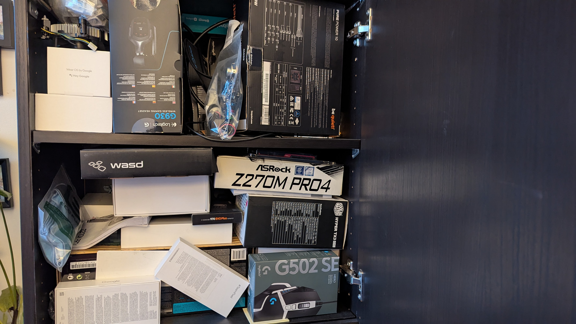 An image of a cupboard where I keep old hardware packed to the brim with boxes, cables, components and such.